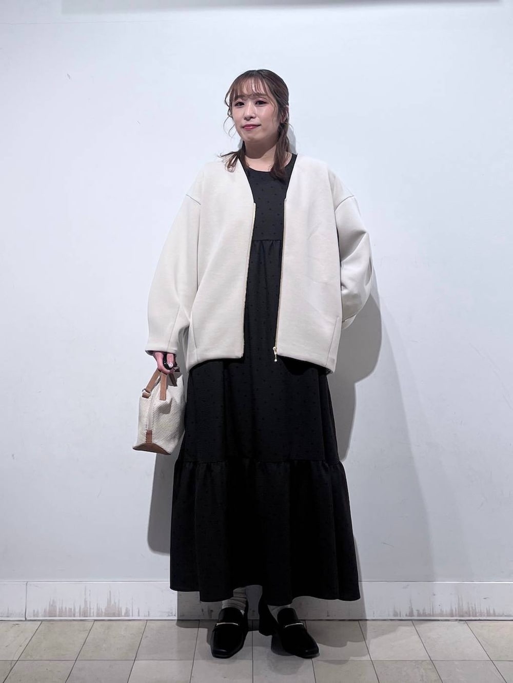 ホワイト系のショルダーバッグ、ブラック系のローファー、ホワイト系のブルゾンを着用したレディースの春コーディネートの5枚目の写真