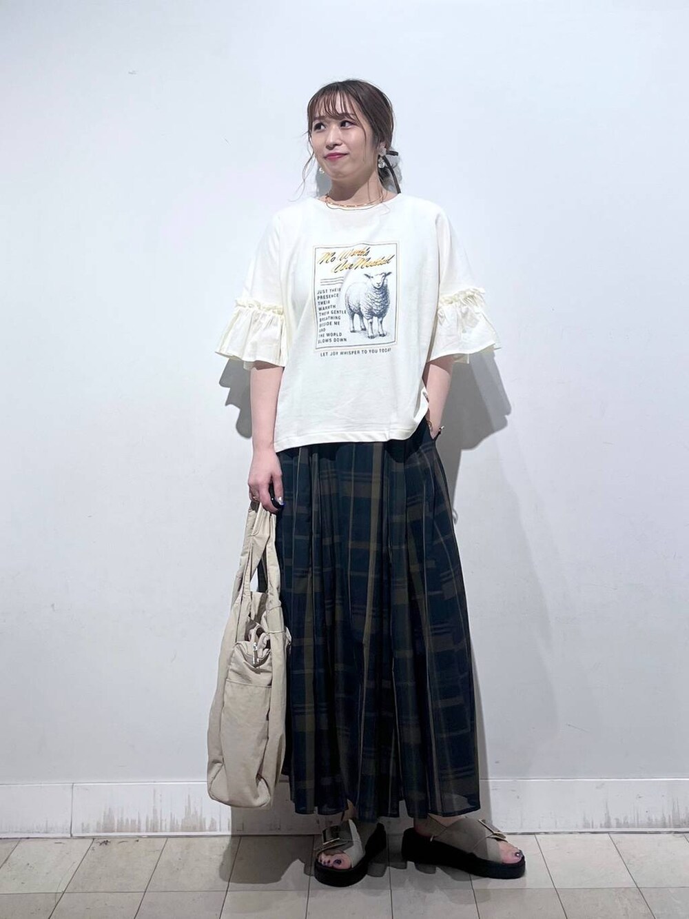 ホワイト系のタンクトップ、ベージュ系のトートバッグ、ベージュ系のサンダルを着用したレディースの秋コーディネートの7枚目の写真