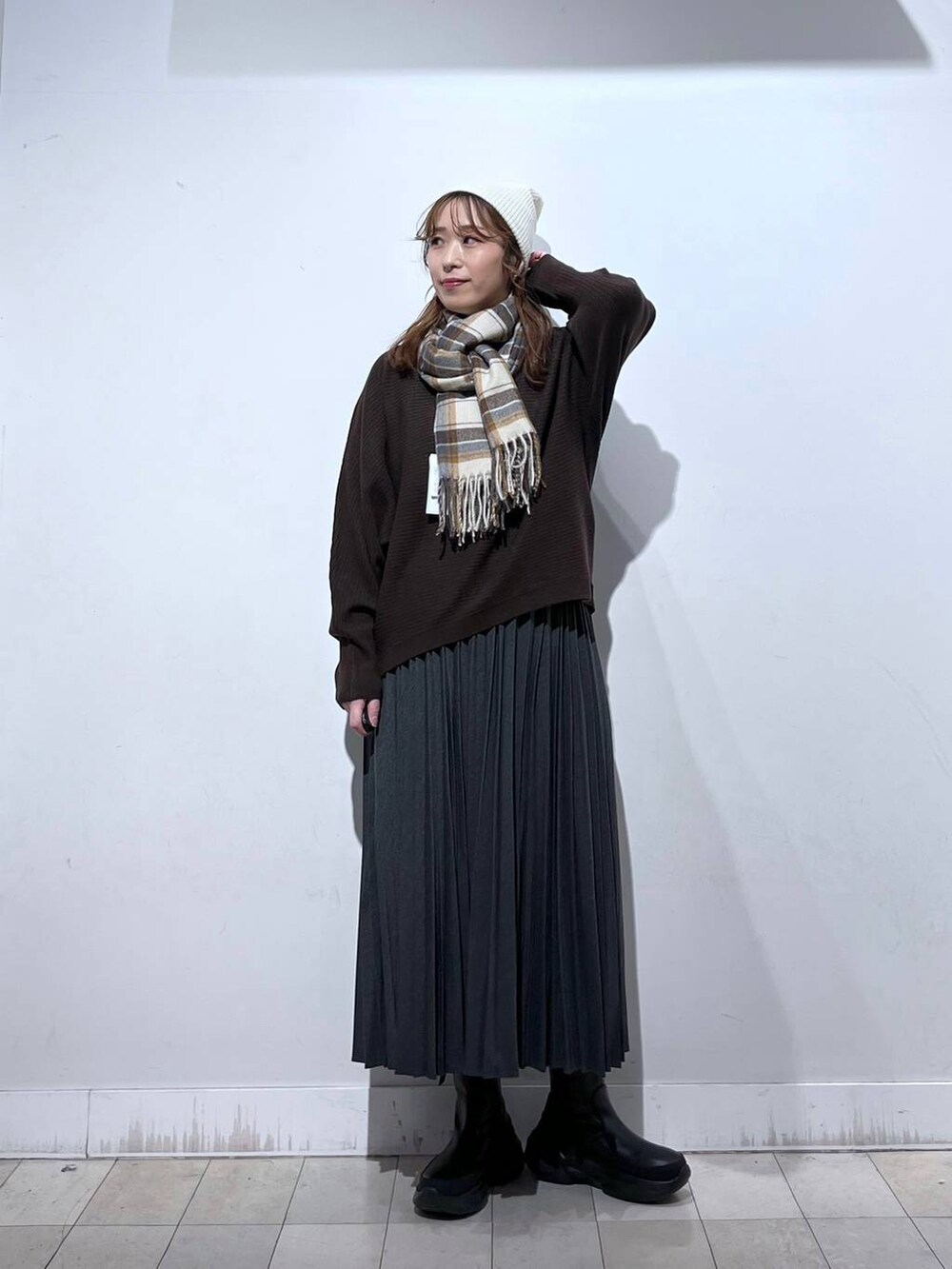 ブラック系のブーツ、グレー系のスカート、ブラウン系のマフラーを着用したレディースの冬コーディネートの4枚目の写真