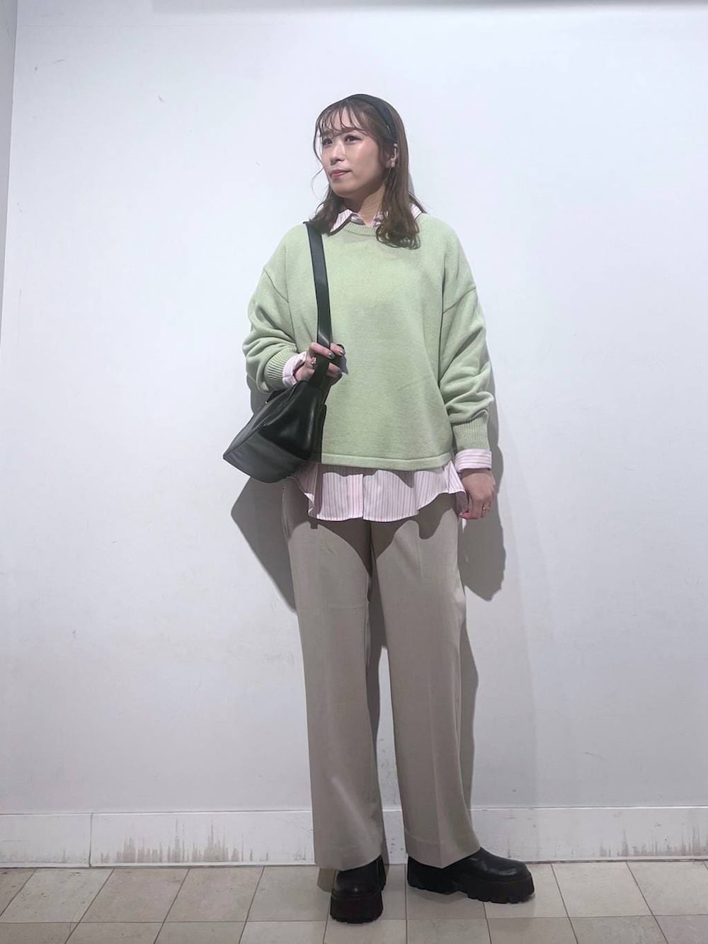 グリーン系のニット/セーター、ピンク系のシャツ/ブラウス、ベージュ系のスラックスを着用したレディースの春コーディネートの7枚目の写真