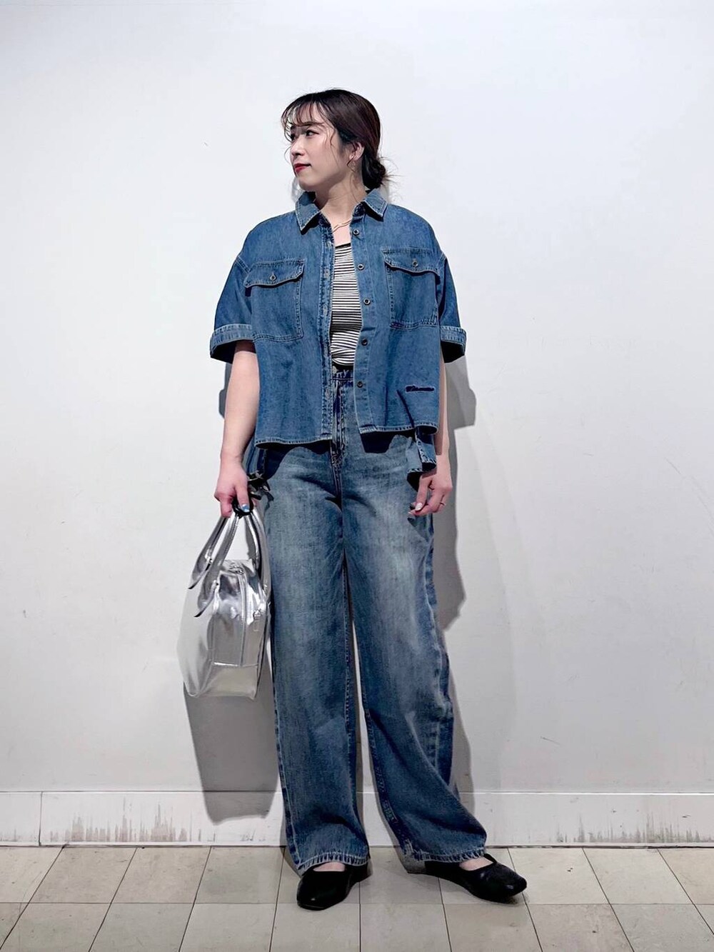 ブルー系のデニムパンツ、その他のパンプス、グレー系のボストンバッグを着用したレディースの春コーディネートの4枚目の写真