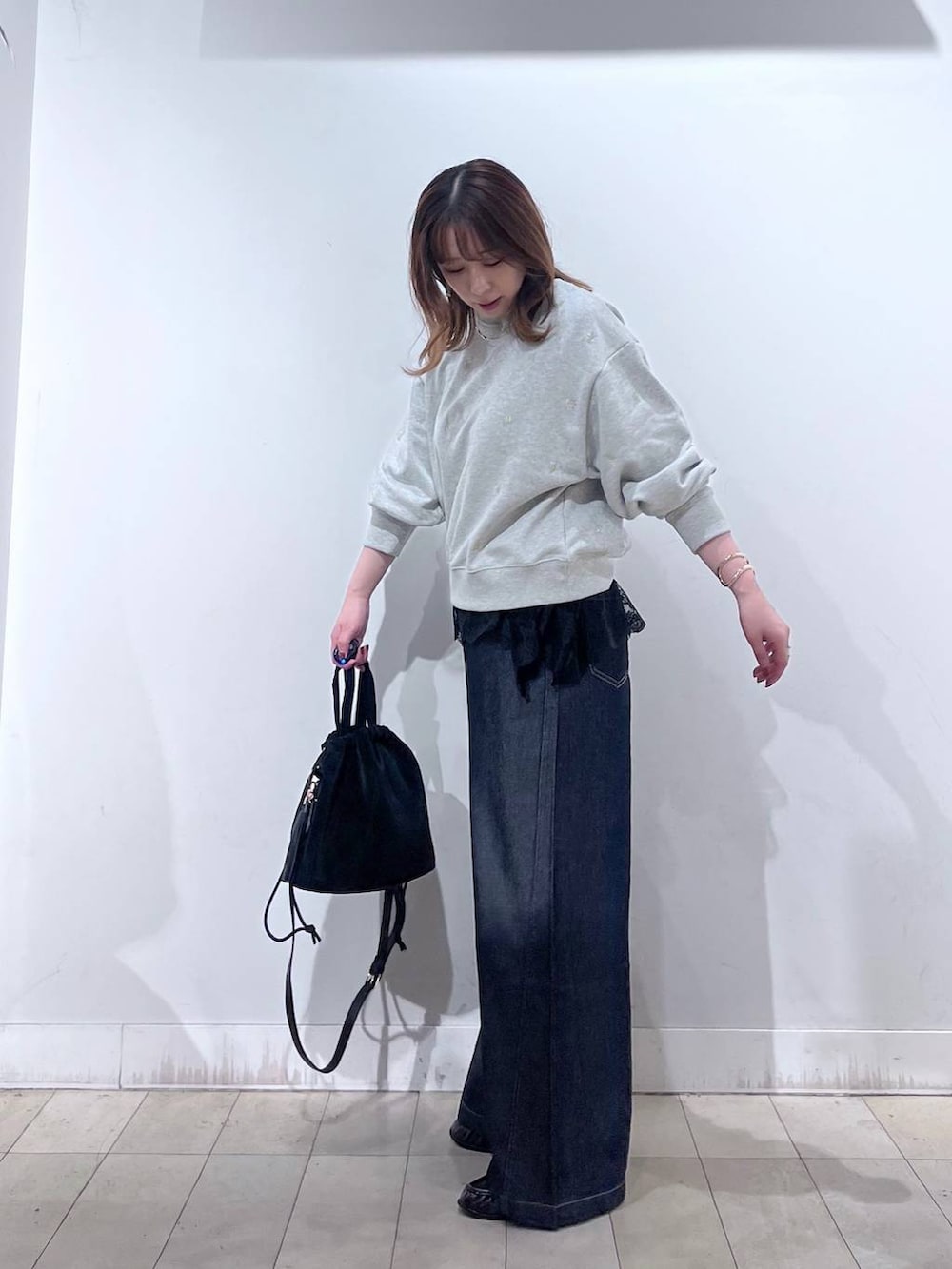 ブラック系のハンドバッグ、グレー系のTシャツ/カットソー、ブラウン系のローファーを着用したレディースの秋コーディネートの3枚目の写真