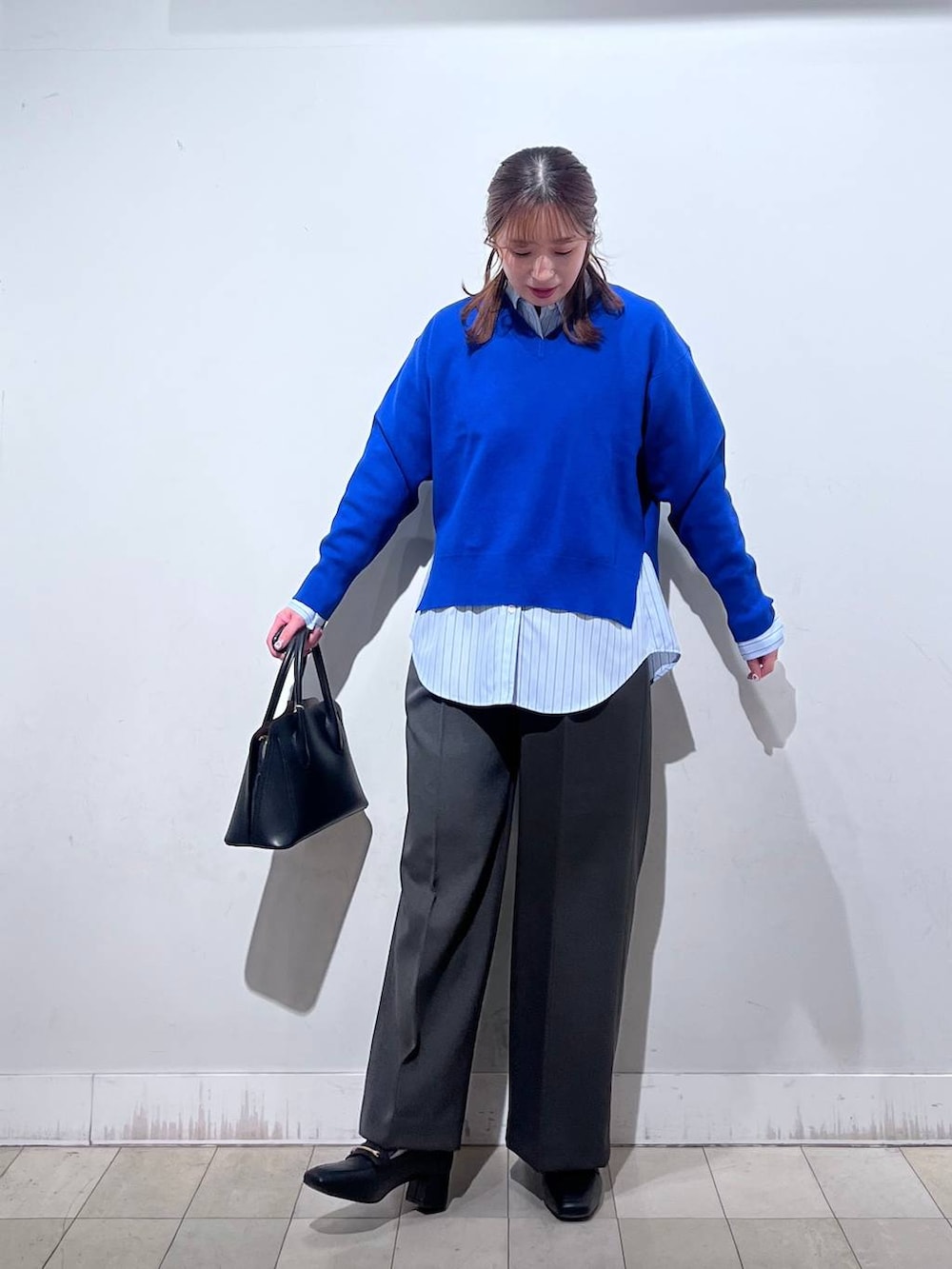 ブラック系のローファー、ブラック系のショルダーバッグ、ブルー系のシャツ/ブラウスを着用したレディースの冬コーディネートの9枚目の写真