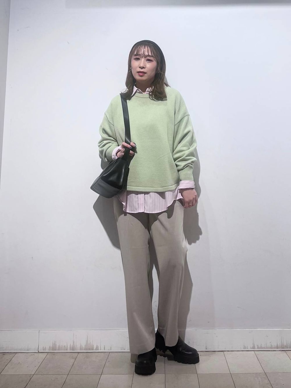 グリーン系のニット/セーター、ピンク系のシャツ/ブラウス、ベージュ系のスラックスを着用したレディースの春コーディネートの8枚目の写真