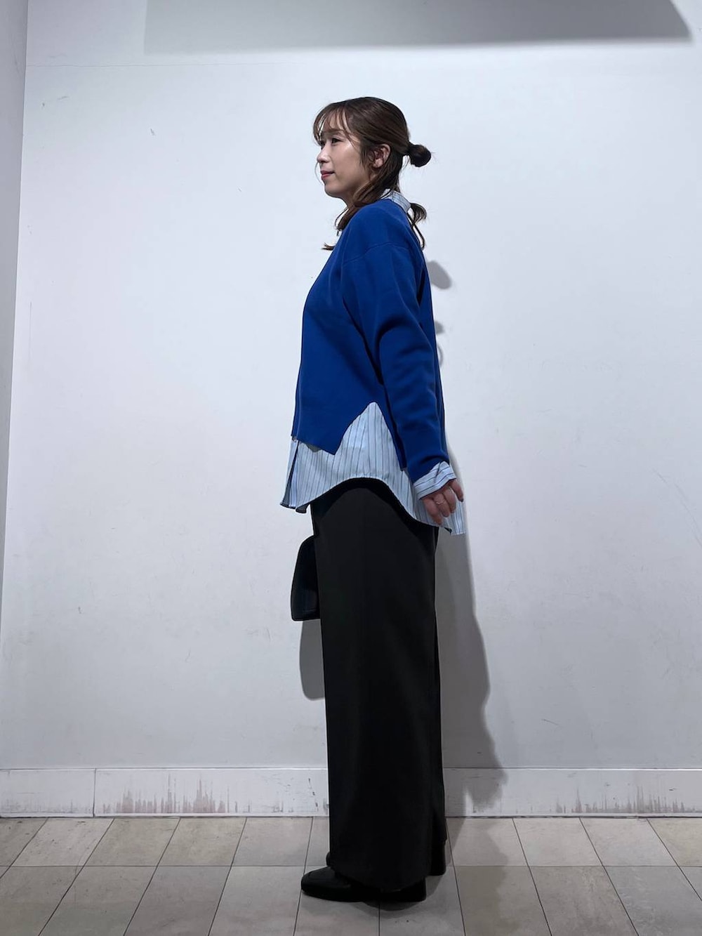 ブラック系のローファー、ブラック系のショルダーバッグ、ブルー系のシャツ/ブラウスを着用したレディースの冬コーディネートの2枚目の写真