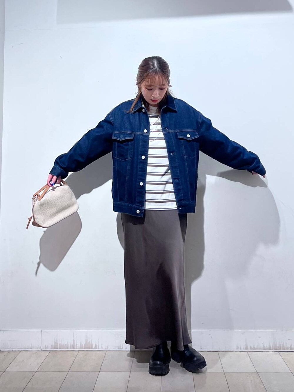 ホワイト系のショルダーバッグ、ブルー系のデニムジャケット、ブラウン系のスカートを着用したレディースの冬コーディネートの4枚目の写真
