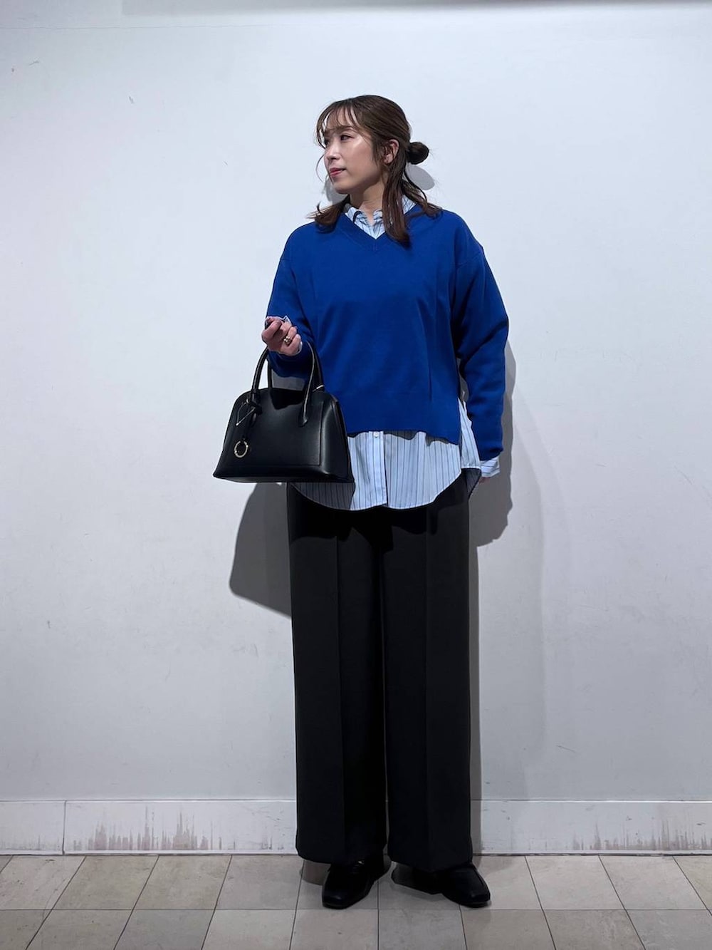 ブラック系のローファー、ブラック系のショルダーバッグ、ブルー系のシャツ/ブラウスを着用したレディースの冬コーディネートの3枚目の写真