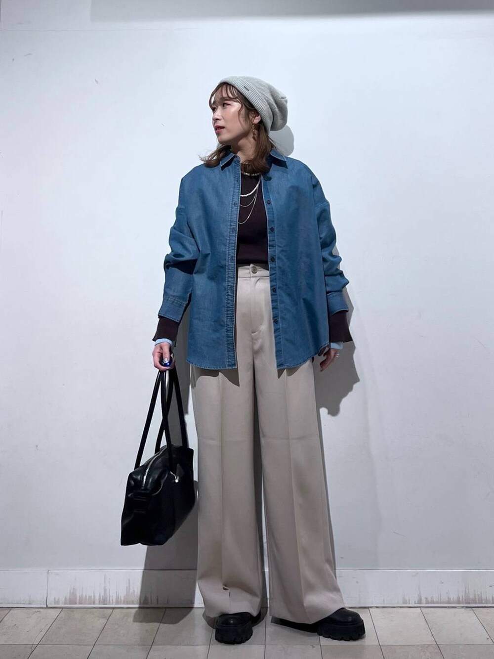 ブラック系のボストンバッグ、ブルー系のシャツ/ブラウス、ベージュ系のその他パンツを着用したレディースの冬コーディネートの5枚目の写真