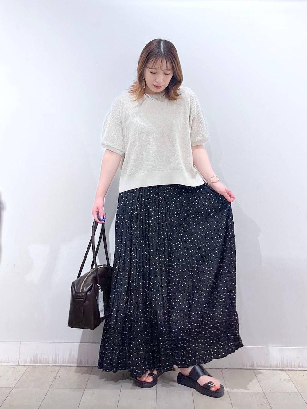 その他のスカート、ブラウン系のボストンバッグ、ホワイト系のタンクトップを着用したレディースの夏コーディネートの4枚目の写真