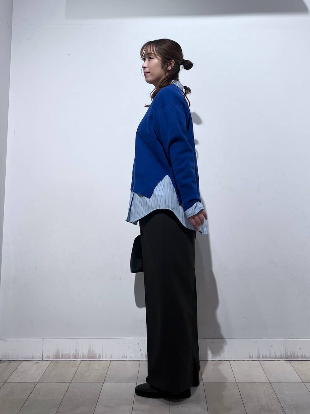 ブラック系のローファー、ブラック系のショルダーバッグ、ブルー系のシャツ/ブラウスを着用したレディースの冬コーディネートの3枚目の写真