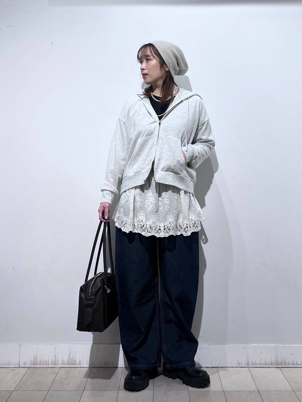 ブラウン系のボストンバッグ、ホワイト系のパーカー、ホワイト系のその他トップスを着用したレディースの冬コーディネートの4枚目の写真