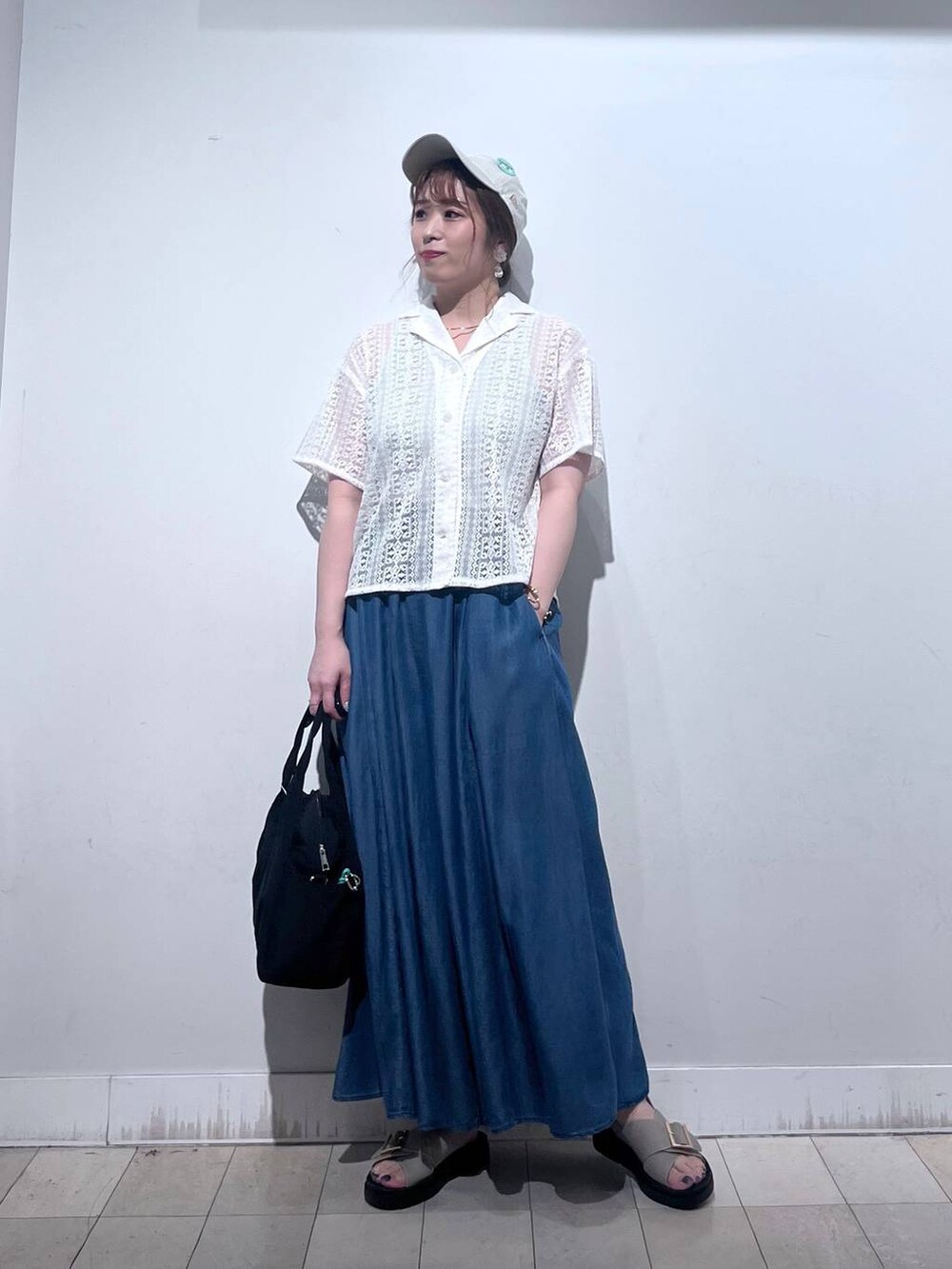 ブラック系のトートバッグ、ブルー系のその他パンツ、ベージュ系のサンダルを着用したレディースの夏コーディネートの3枚目の写真