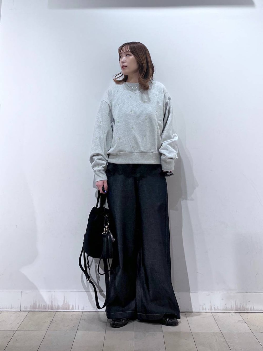 ブラック系のハンドバッグ、グレー系のTシャツ/カットソー、ブラウン系のローファーを着用したレディースの秋コーディネートの4枚目の写真