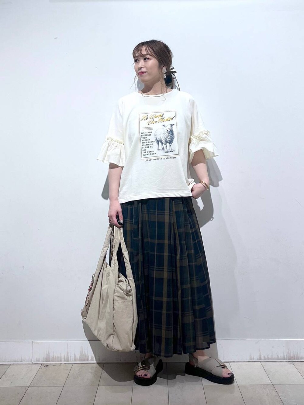 ホワイト系のタンクトップ、ベージュ系のトートバッグ、ベージュ系のサンダルを着用したレディースの秋コーディネートの5枚目の写真