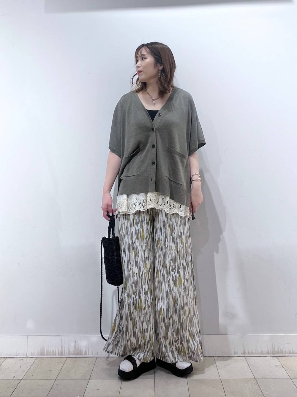 ブラウン系のカーディガン/ボレロ、ベージュ系のその他パンツ、ホワイト系のその他トップスを着用したレディースの夏コーディネートの6枚目の写真