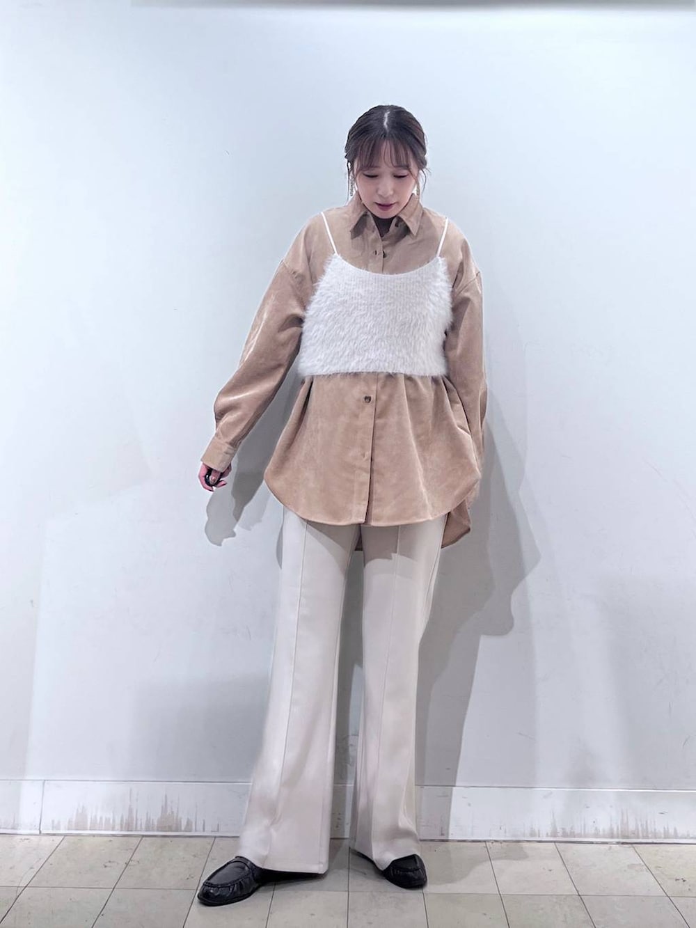 ベージュ系のその他パンツ、ホワイト系のベスト、ブラック系のショルダーバッグを着用したレディースの秋コーディネートの3枚目の写真
