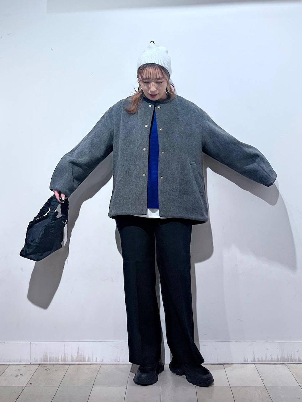 ブラック系のスニーカー、ブラック系のショルダーバッグ、グレー系のノーカラーコートを着用したレディースの秋コーディネートの9枚目の写真