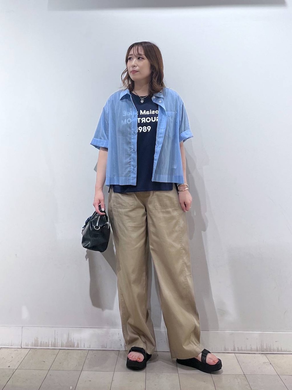 ブルー系のシャツ/ブラウス、ブルー系のTシャツ/カットソー、ブラック系のボストンバッグを着用したレディースの夏コーディネートの6枚目の写真