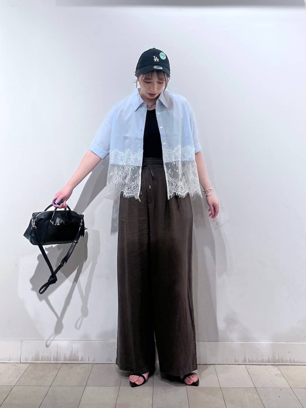 ブラウン系のその他パンツ、ブラック系のボストンバッグ、ブラック系のサンダルを着用したレディースの夏コーディネートの3枚目の写真