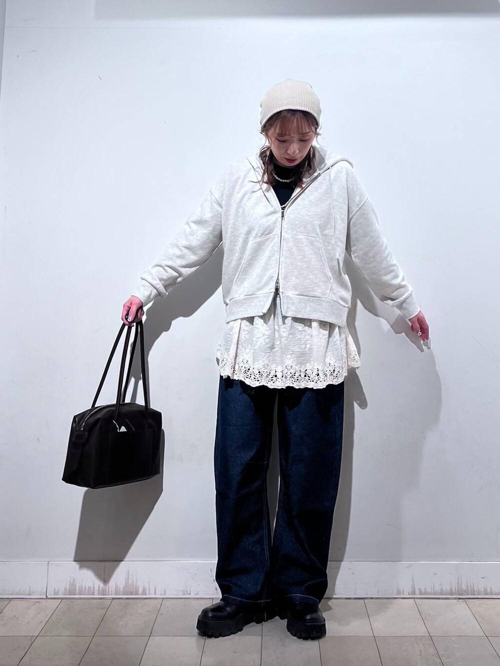 ブラウン系のボストンバッグ、ホワイト系のパーカー、ホワイト系のその他トップスを着用したレディースの冬コーディネートの5枚目の写真