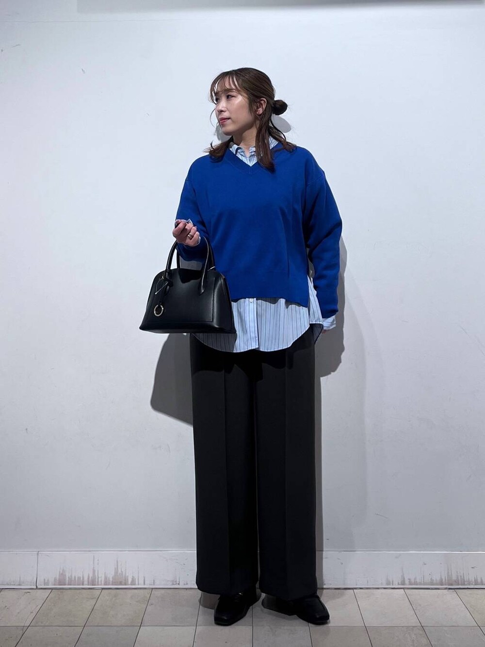 ブラック系のローファー、ブラック系のショルダーバッグ、ブルー系のシャツ/ブラウスを着用したレディースの冬コーディネートの7枚目の写真