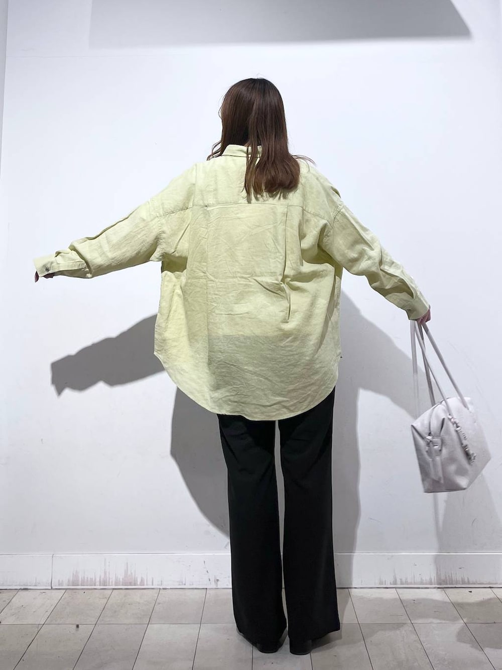 ホワイト系のボストンバッグ、ブラック系のブーツ、イエロー系のシャツ/ブラウスを着用したレディースの春コーディネートの6枚目の写真