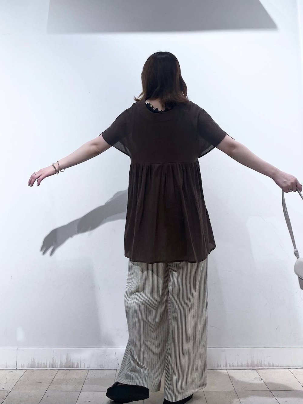 ベージュ系のショルダーバッグ、ベージュ系のその他パンツ、ブラウン系のシャツ/ブラウスを着用したレディースの夏コーディネートの5枚目の写真