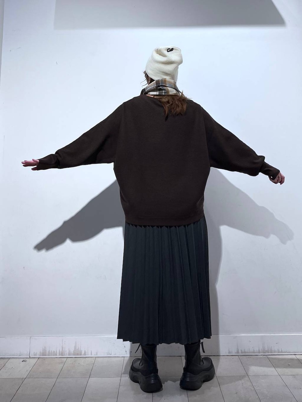 ブラック系のブーツ、グレー系のスカート、ブラウン系のマフラーを着用したレディースの冬コーディネートの6枚目の写真