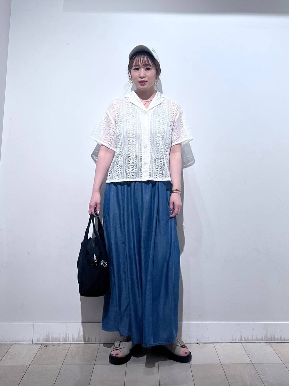 ブラック系のトートバッグ、ブルー系のその他パンツ、ベージュ系のサンダルを着用したレディースの夏コーディネートの7枚目の写真