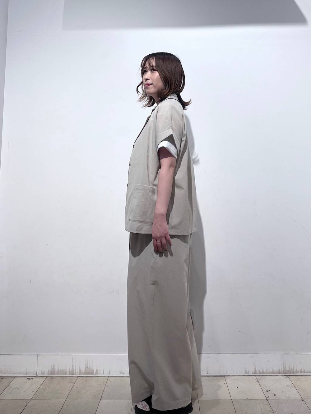 ブラウン系のショルダーバッグ、ホワイト系のTシャツ/カットソー、ブラック系のサンダルを着用したレディースの春コーディネートの2枚目の写真