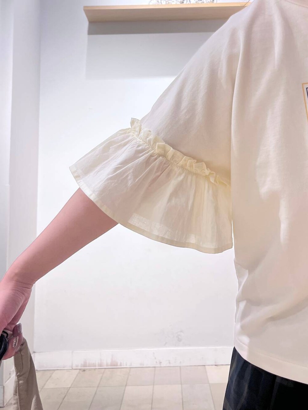 ホワイト系のタンクトップ、ベージュ系のトートバッグ、ベージュ系のサンダルを着用したレディースの秋コーディネートの2枚目の写真