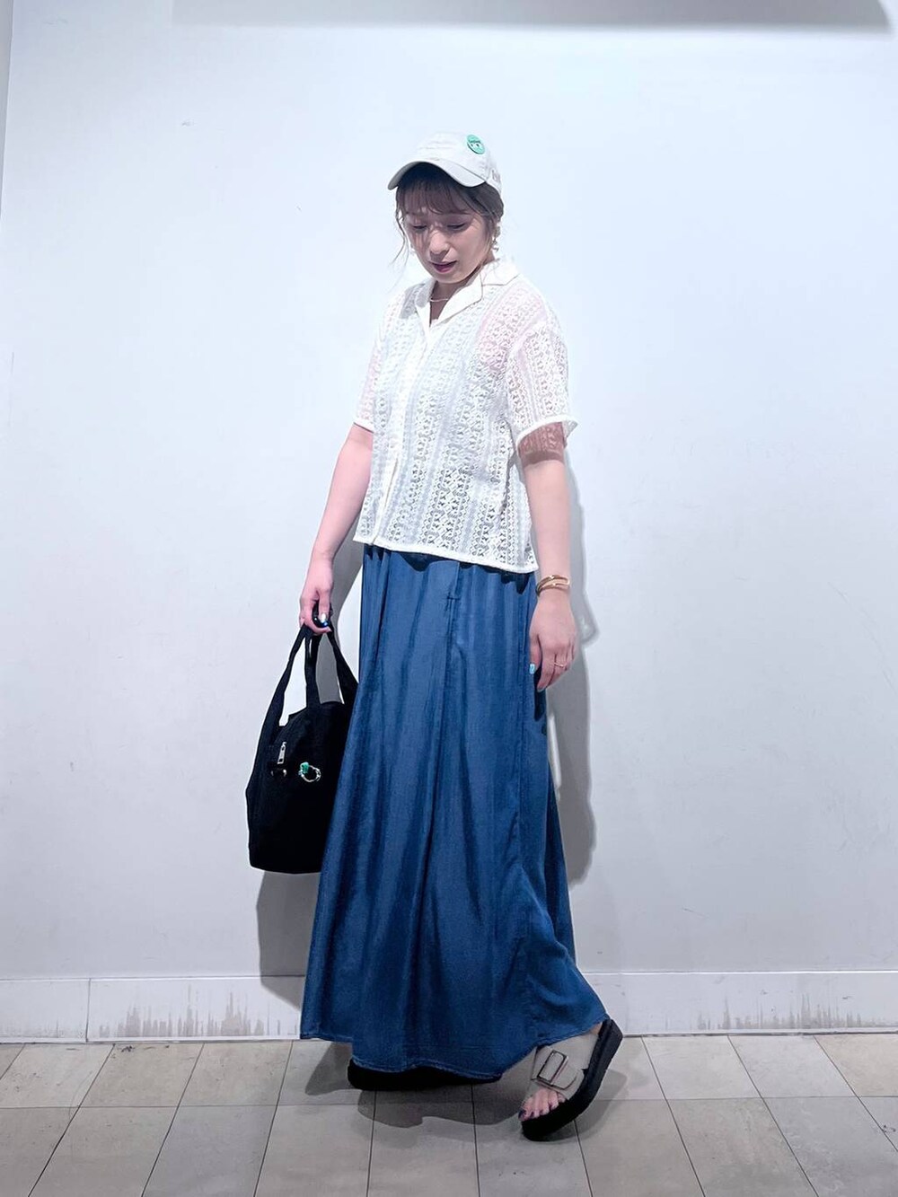 ブラック系のトートバッグ、ブルー系のその他パンツ、ベージュ系のサンダルを着用したレディースの夏コーディネートの5枚目の写真
