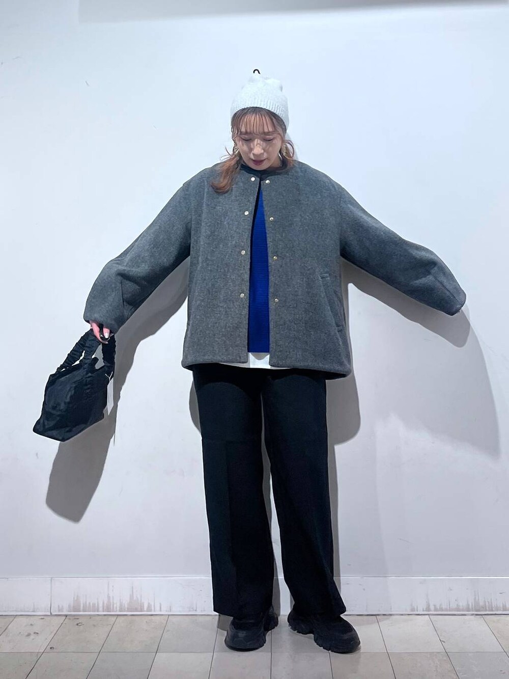 ブラック系のスニーカー、ブラック系のショルダーバッグ、グレー系のノーカラーコートを着用したレディースの秋コーディネートの5枚目の写真