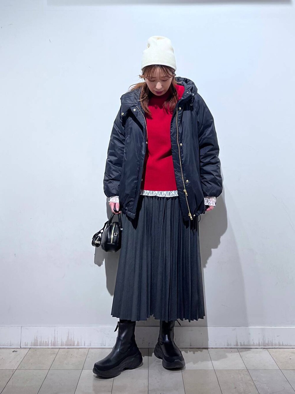 ブラック系のダウンジャケット/コート、ホワイト系のTシャツ/カットソー、レッド系のニット/セーターを着用したレディースの冬コーディネートの4枚目の写真