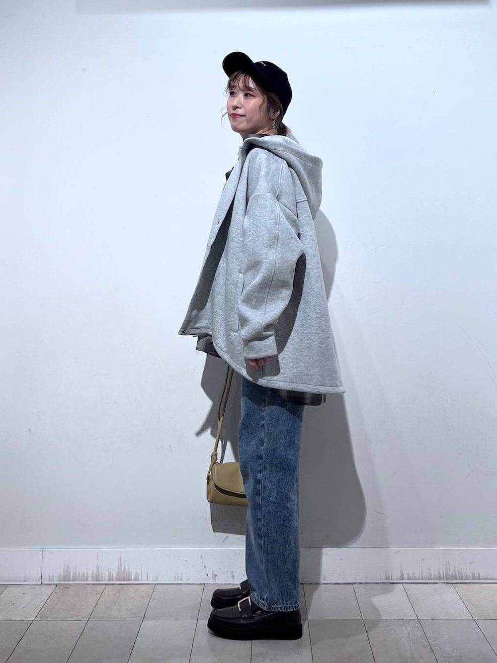 ブラック系のローファー、ブルー系のデニムパンツ、ホワイト系のTシャツ/カットソーを着用したレディースの秋コーディネートの2枚目の写真