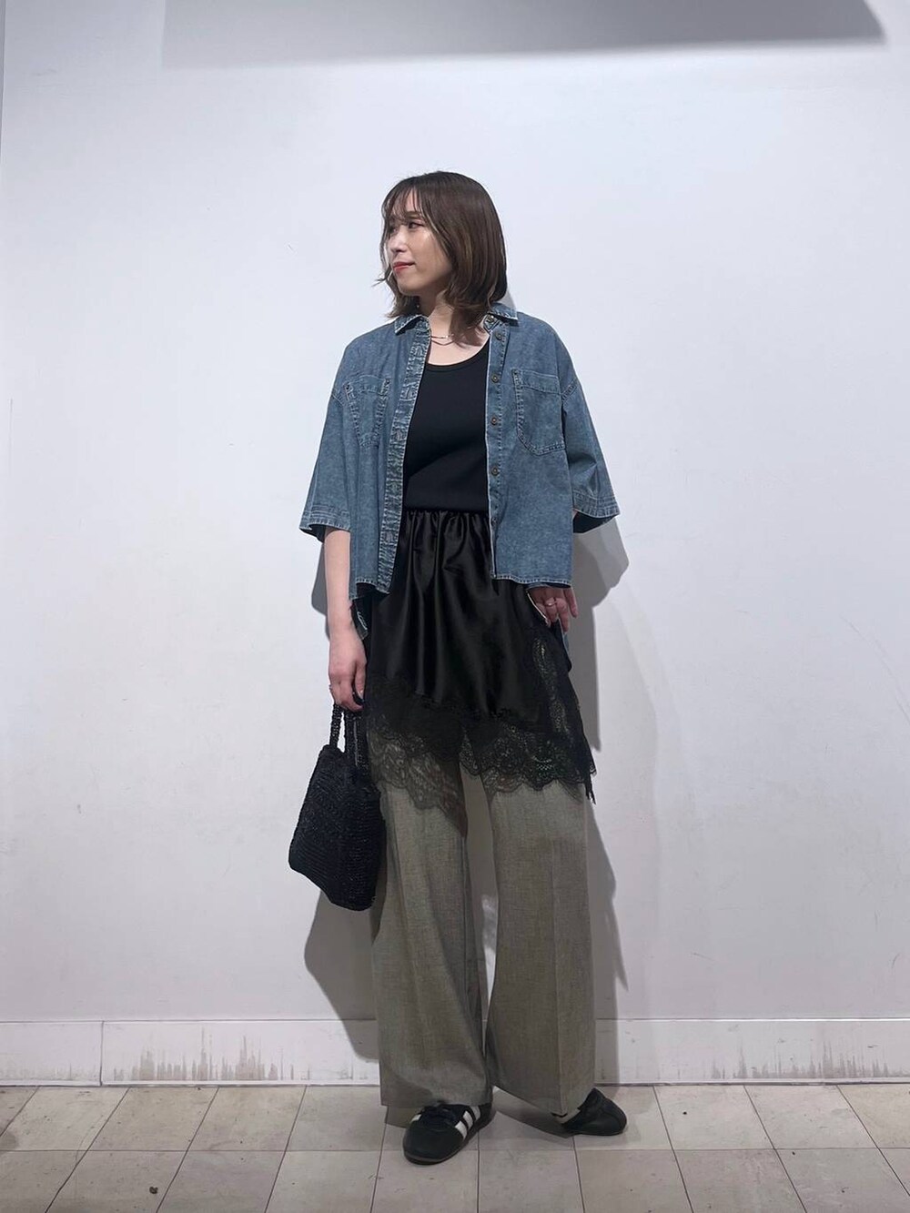 ベージュ系のその他パンツ、ブラック系のタンクトップ、ブラック系のその他トップスを着用したレディースの春コーディネートの9枚目の写真