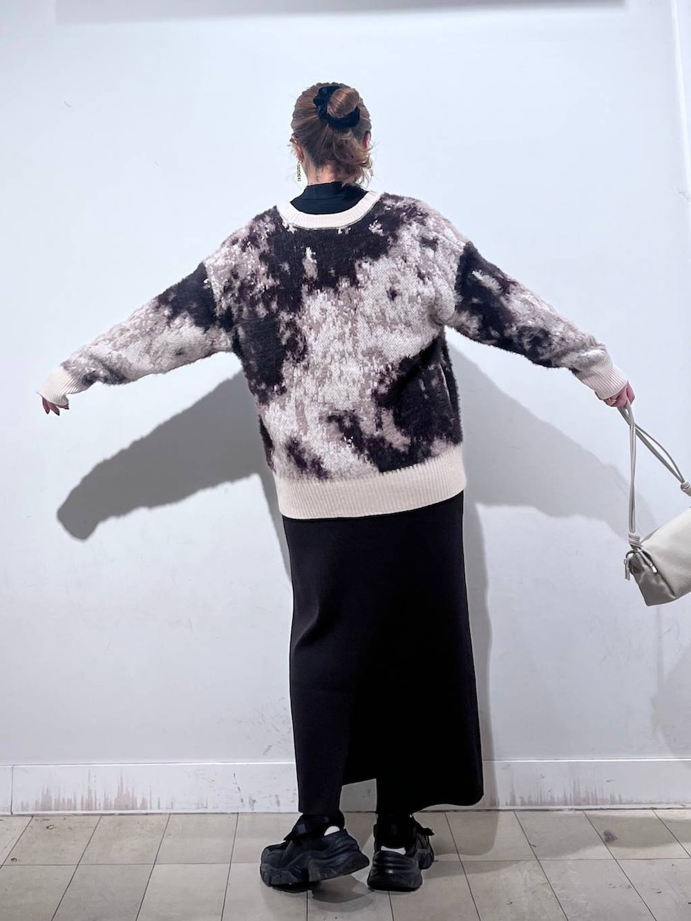 ブラック系のスニーカー、ブラック系のニット/セーター、ベージュ系のショルダーバッグを着用したレディースの秋コーディネートの9枚目の写真