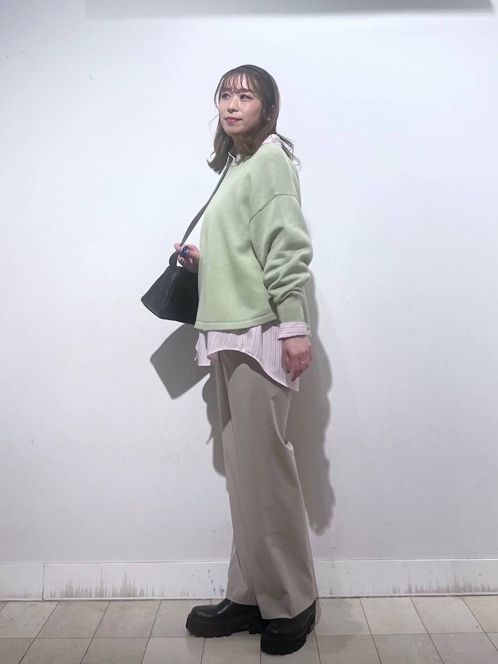 グリーン系のニット/セーター、ピンク系のシャツ/ブラウス、ベージュ系のスラックスを着用したレディースの春コーディネートの2枚目の写真