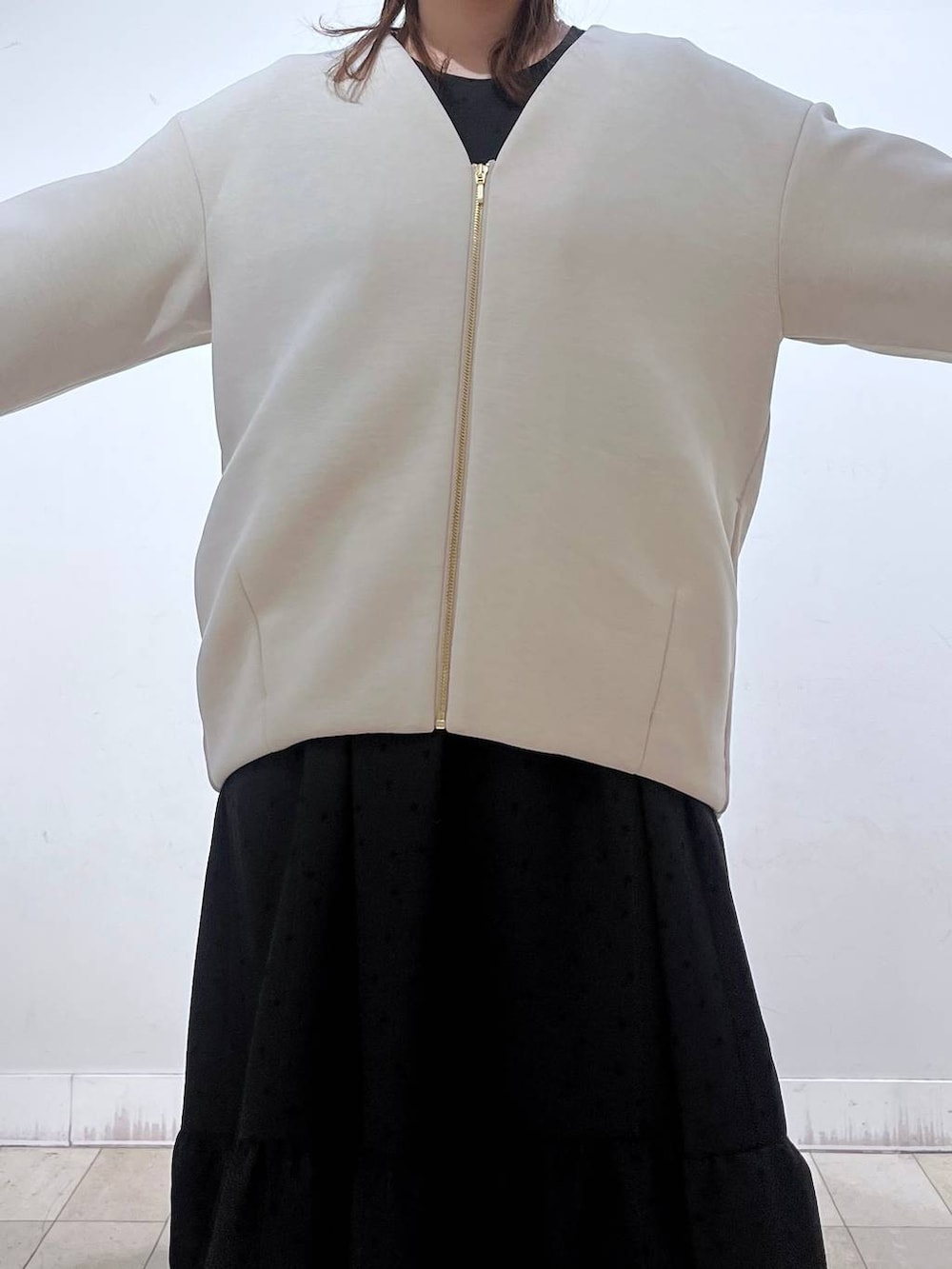 ホワイト系のショルダーバッグ、ブラック系のローファー、ホワイト系のブルゾンを着用したレディースの春コーディネートの3枚目の写真