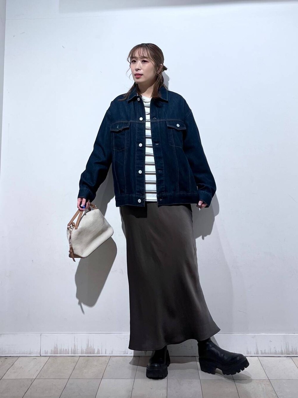 ホワイト系のショルダーバッグ、ブルー系のデニムジャケット、ブラウン系のスカートを着用したレディースの冬コーディネートの6枚目の写真