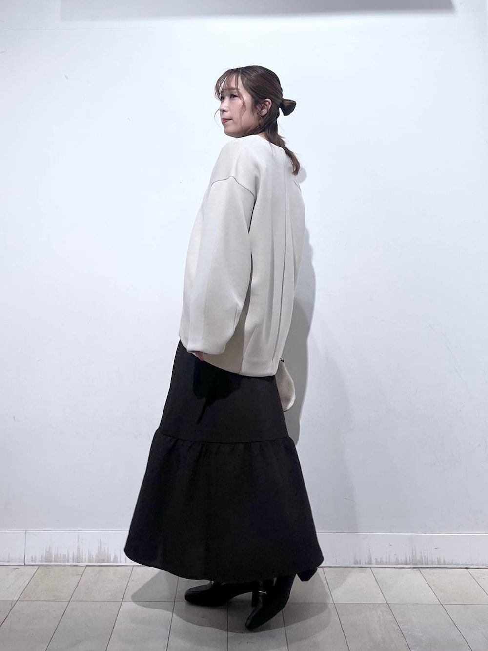 ホワイト系のショルダーバッグ、ブラック系のローファー、ホワイト系のブルゾンを着用したレディースの春コーディネートの2枚目の写真