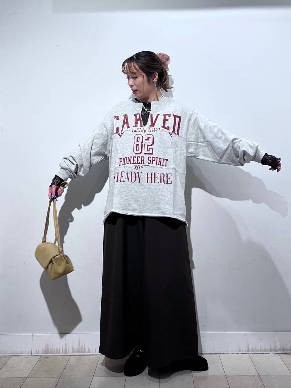 ブラック系のローファー、イエロー系のショルダーバッグ、ブラック系のTシャツ/カットソーを着用したレディースの秋コーディネートの2枚目の写真