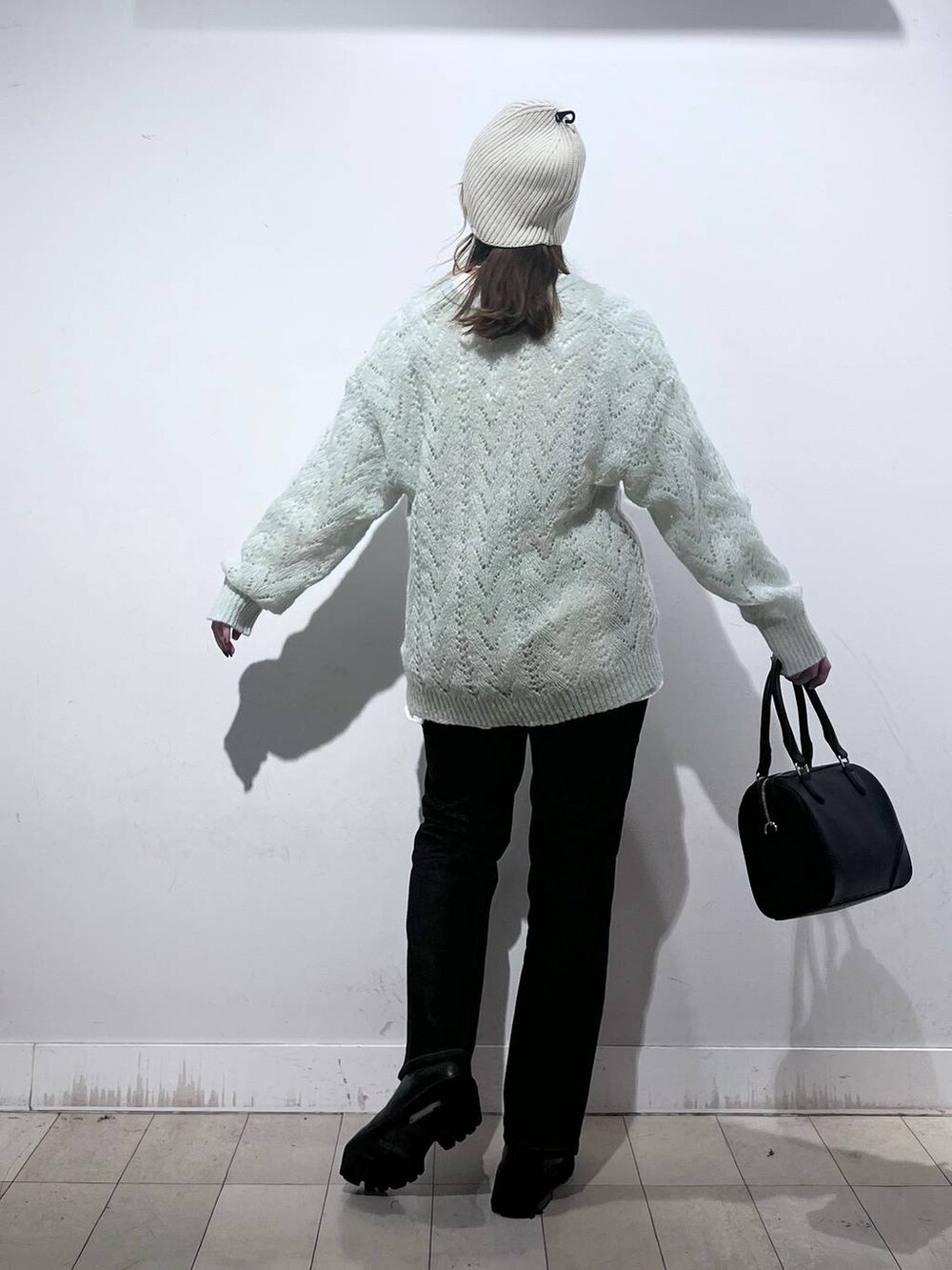 ブラック系のデニムパンツ、ホワイト系のTシャツ/カットソー、ブラック系のボストンバッグを着用したレディースの秋コーディネートの7枚目の写真