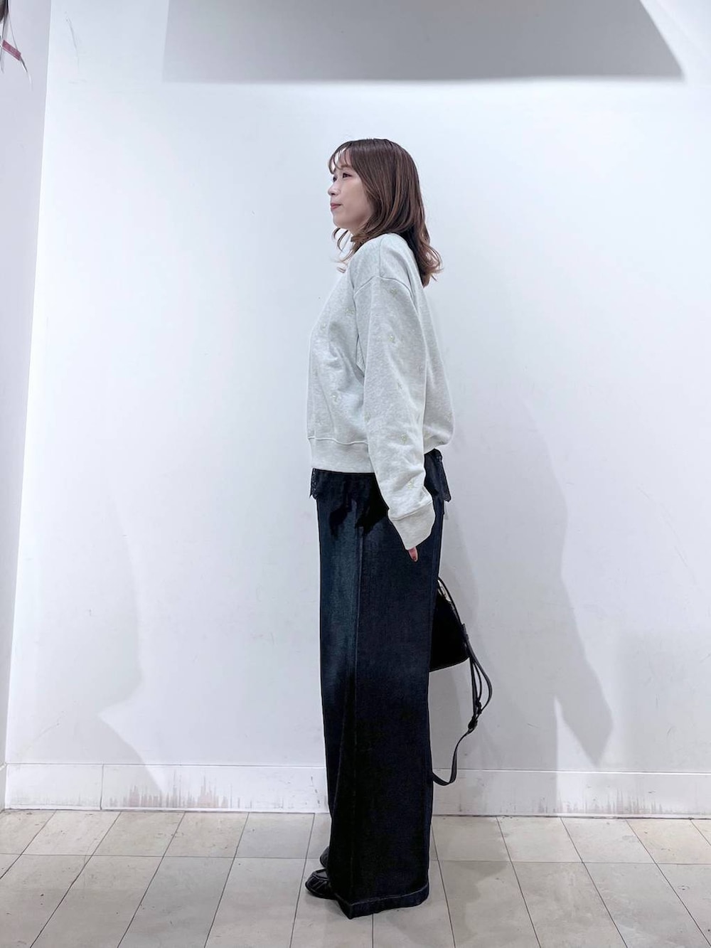 ブラック系のハンドバッグ、グレー系のTシャツ/カットソー、ブラウン系のローファーを着用したレディースの秋コーディネートの2枚目の写真