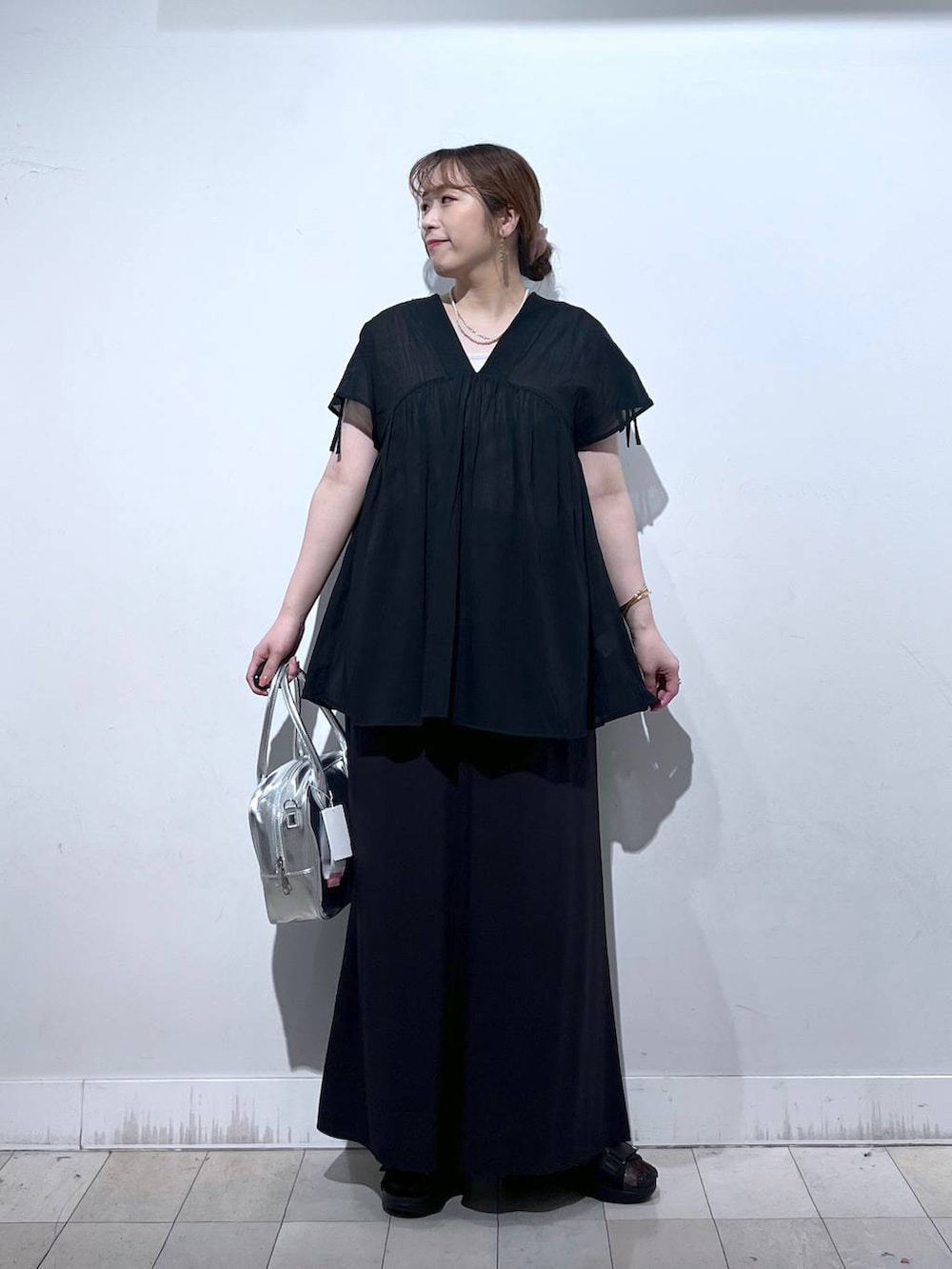 グレー系のボストンバッグ、ブラック系のサンダル、ブラック系のシャツ/ブラウスを着用したレディースの夏コーディネートの6枚目の写真