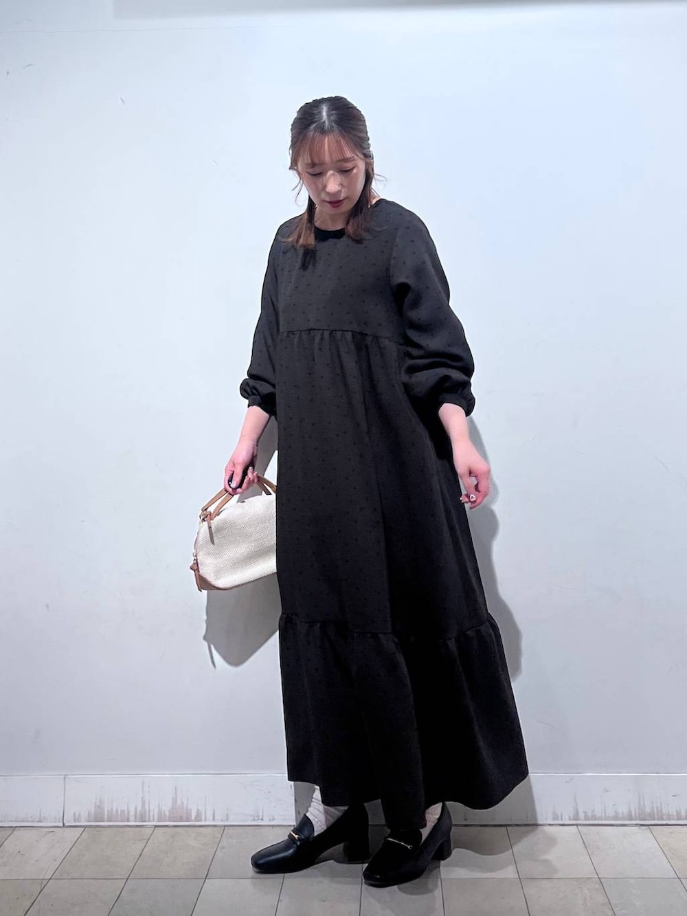 ホワイト系のショルダーバッグ、ブラック系のローファー、ホワイト系のTシャツ/カットソーを着用したレディースの春コーディネートの3枚目の写真