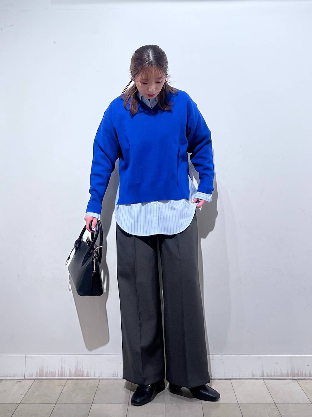 ブラック系のローファー、ブラック系のショルダーバッグ、ブルー系のシャツ/ブラウスを着用したレディースの冬コーディネートの5枚目の写真