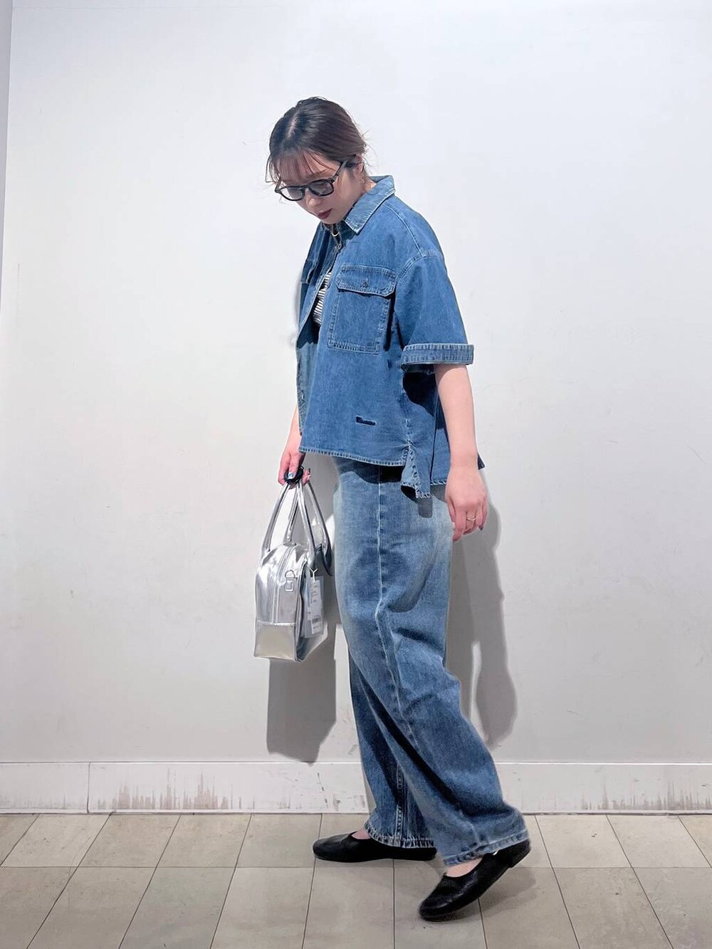 ブルー系のデニムパンツ、その他のパンプス、グレー系のボストンバッグを着用したレディースの春コーディネートの3枚目の写真