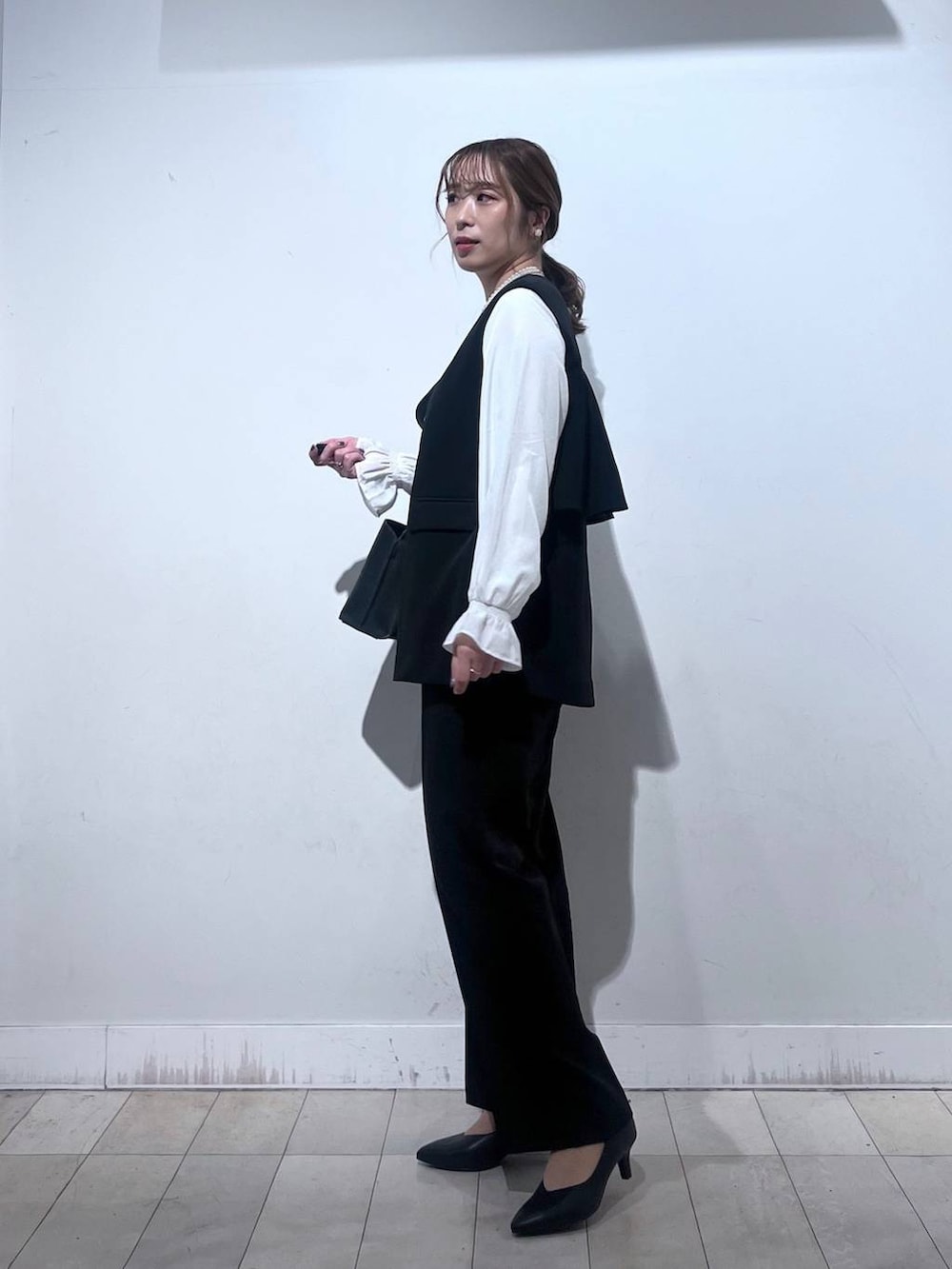 ブラック系のパンプス、ブルー系のセットアップ、ブラック系のショルダーバッグを着用したレディースの冬コーディネートの4枚目の写真