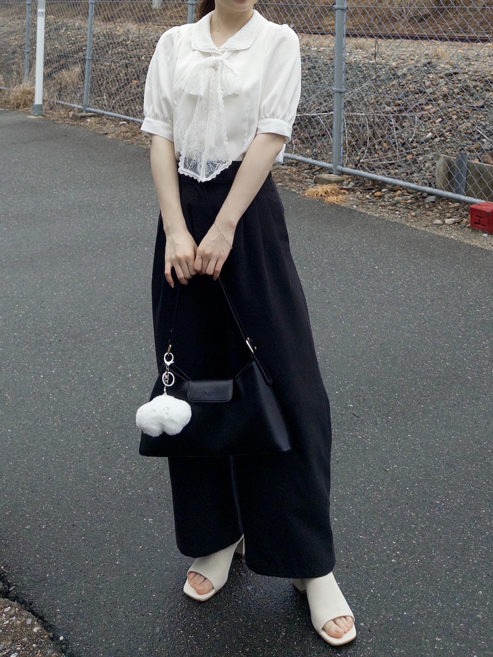 ホワイト系のシャツ/ブラウス、ブラック系のその他パンツ、ブラック系のハンドバッグを着用したレディースの春コーディネートの3枚目の写真